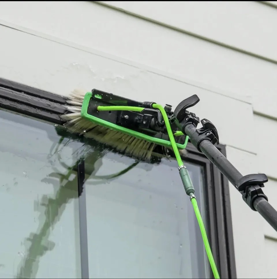PrimeTime water-fed brush cleaning the edge of exterior glass