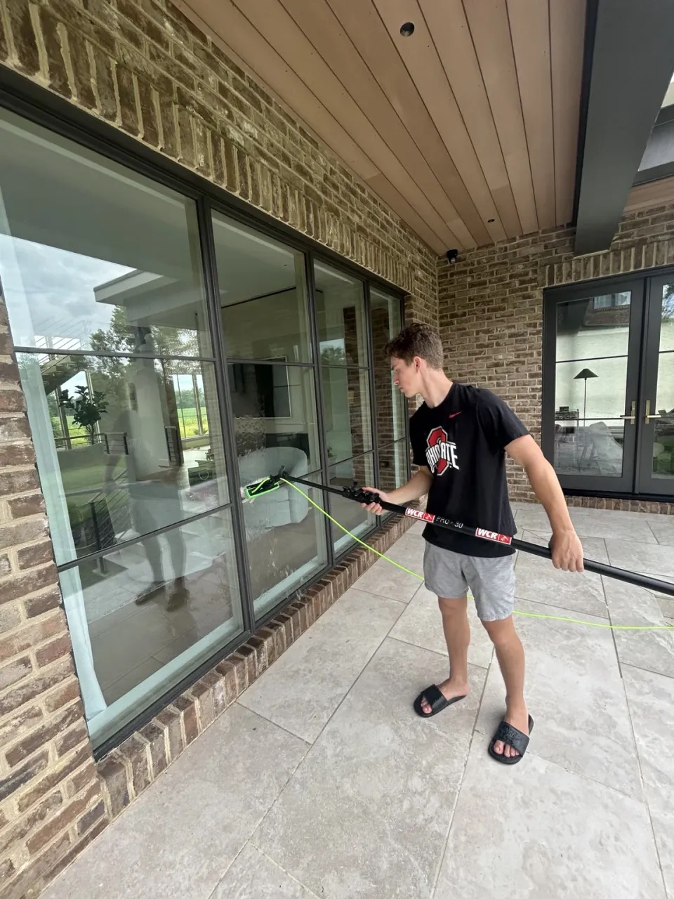 PrimeTime cleaner washing a large wall of exterior glass