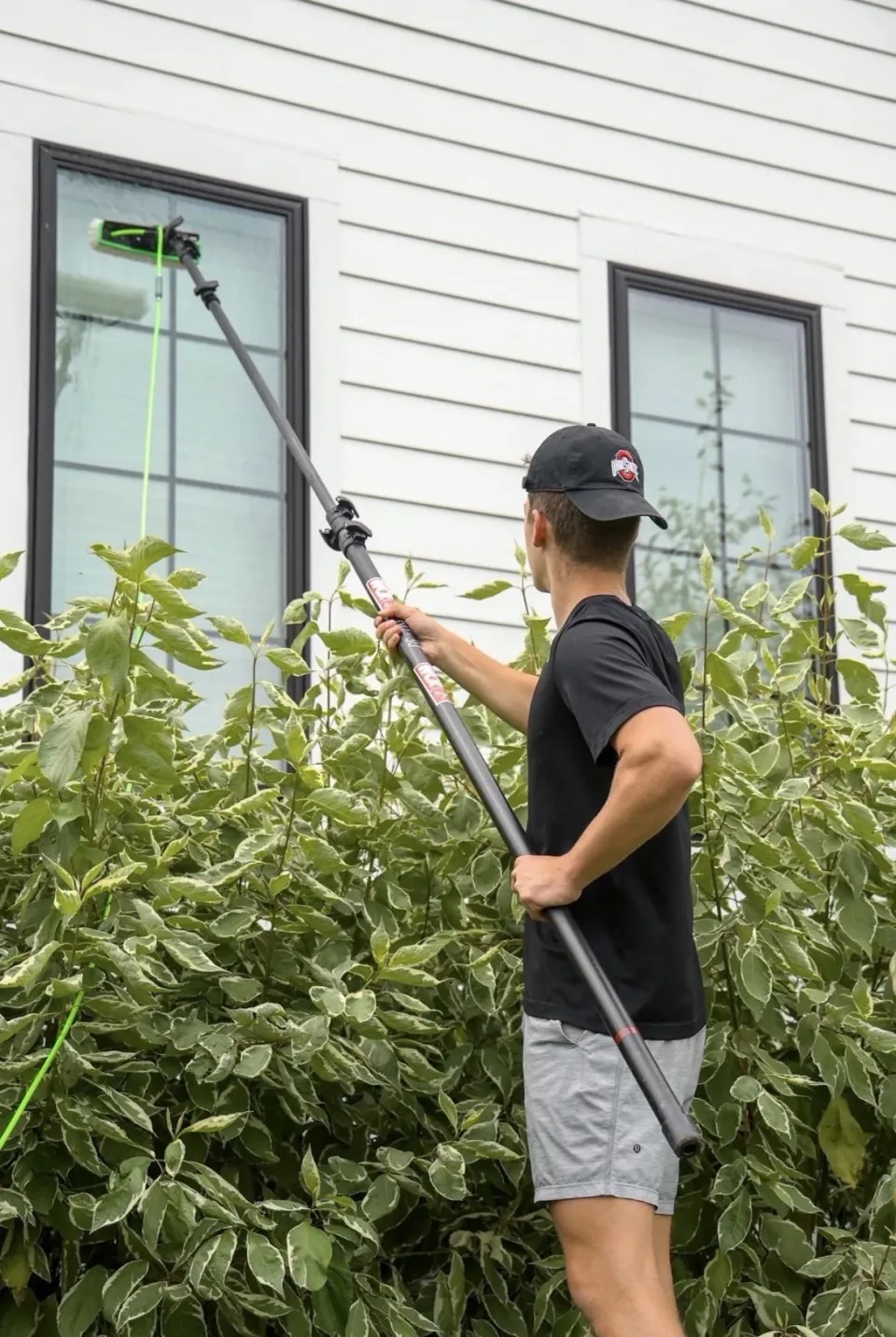PrimeTime cleaner using a water-fed pole on upper-story residential exterior windows